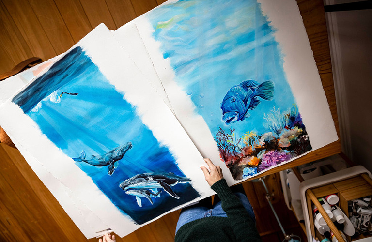 Image of two paintings; humpback whales and blue groper.