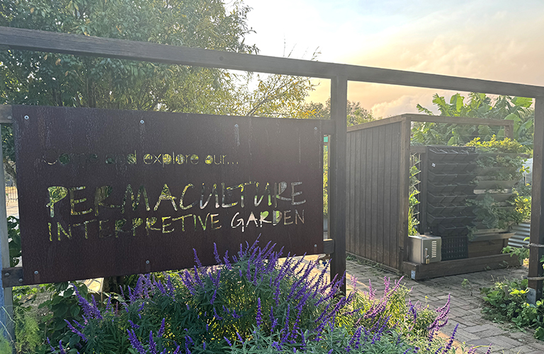 An image of a sign to a permaculture garden