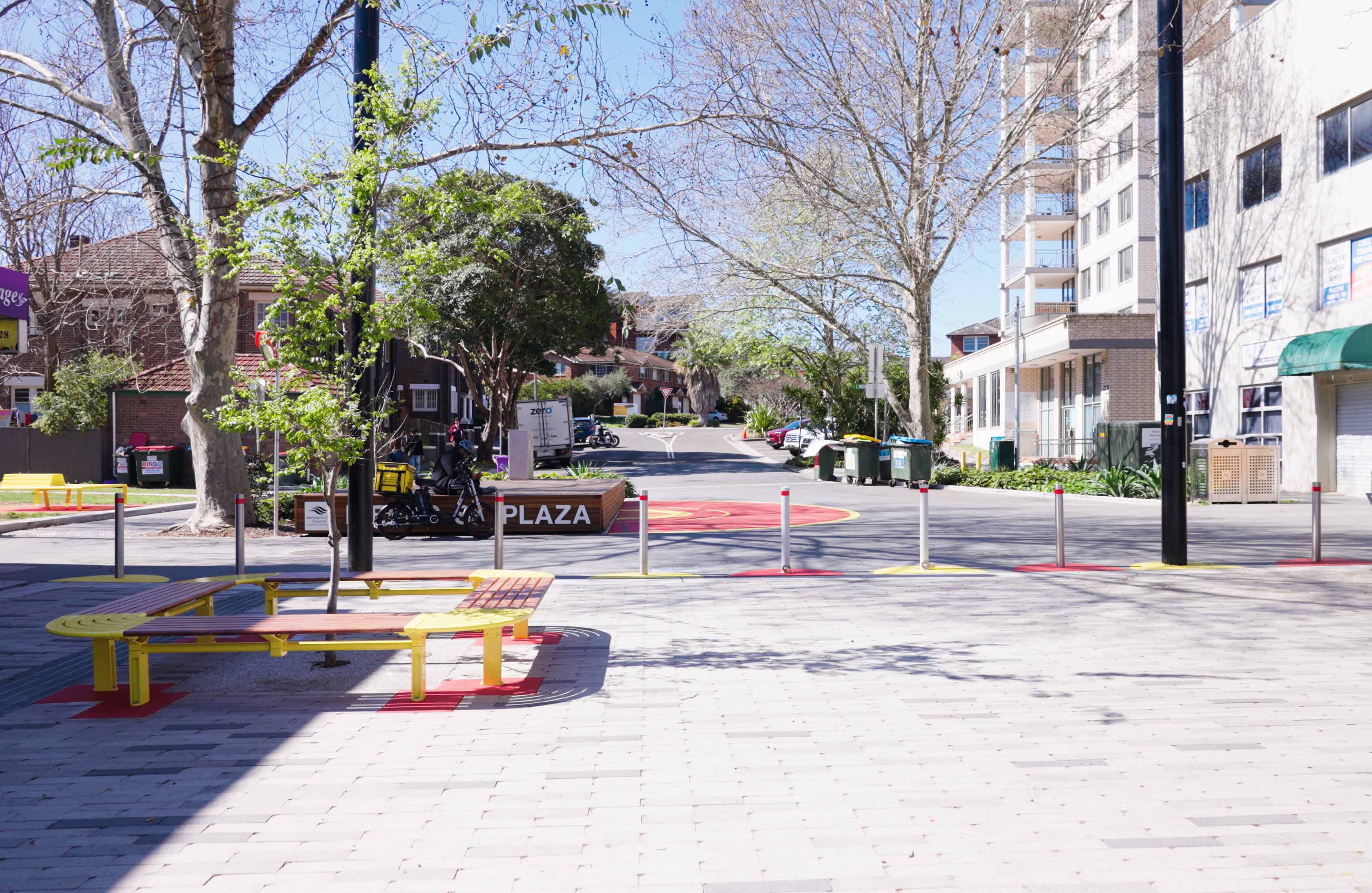 An image of a plaza with colourful seats and paintings on the pavement.